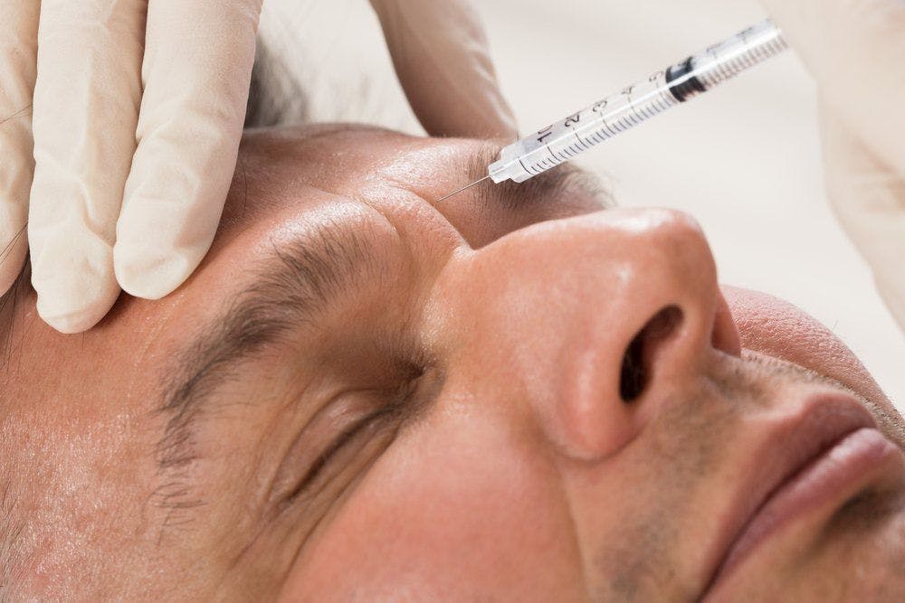 man getting injection in forehead
